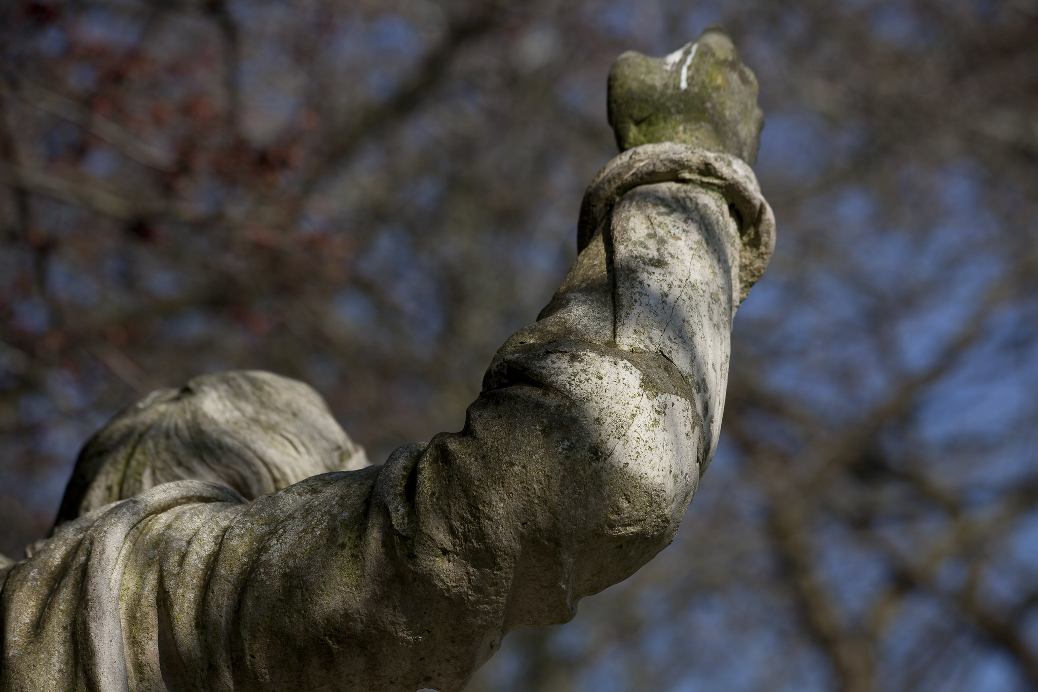 Statue facing away, arm raised