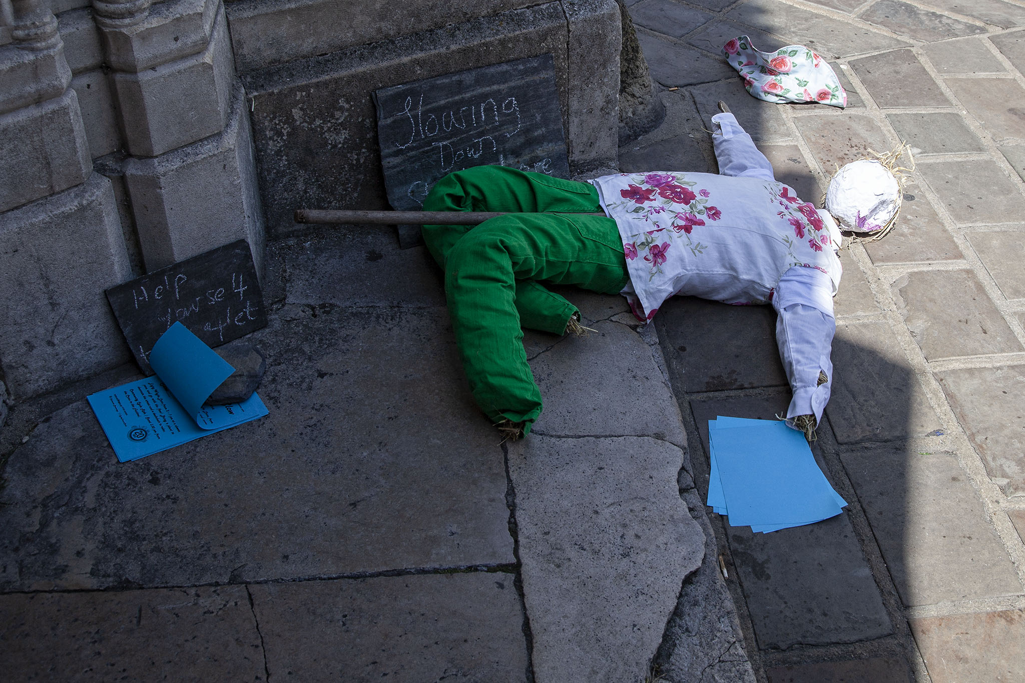 Scarecrow laying on paved pedestrianised area